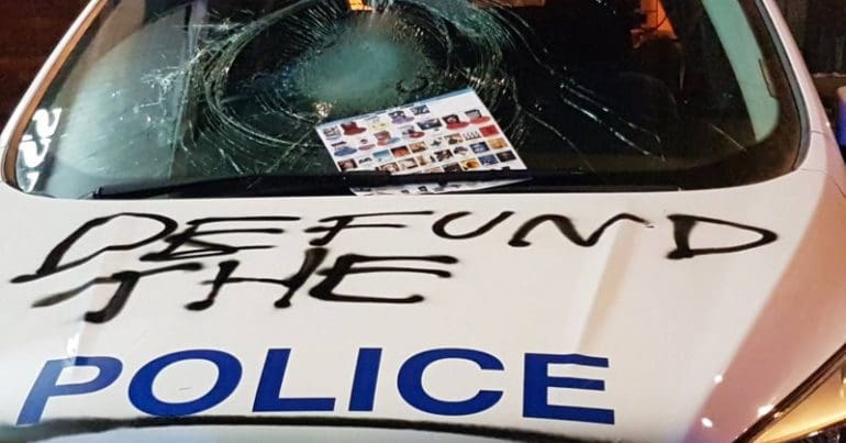 A police car emblazoned with the words 'Defund the Police'