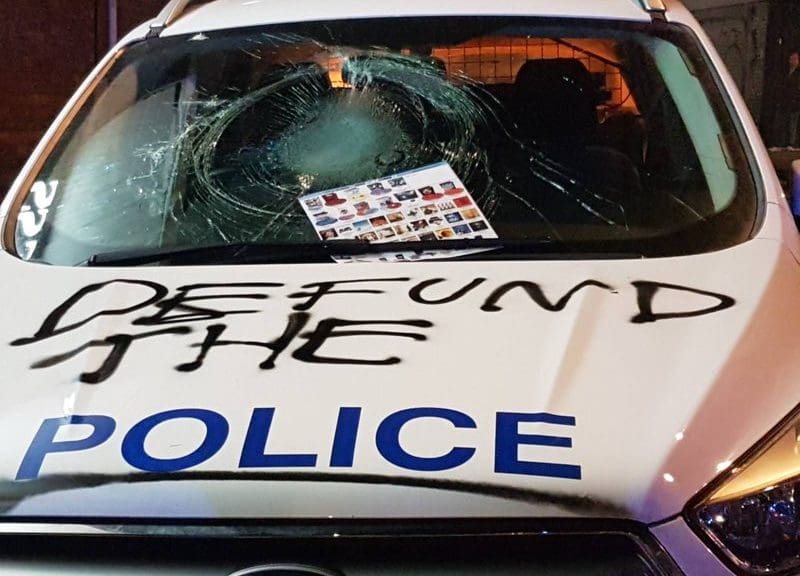 A police car emblazoned with the words 'Defund the Police'