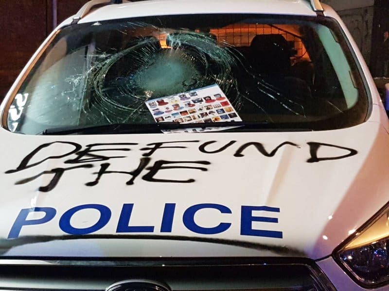 A police car emblazoned with the words 'Defund the Police'