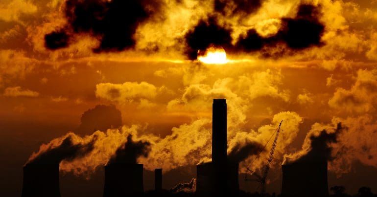 The sun setting over a power plant