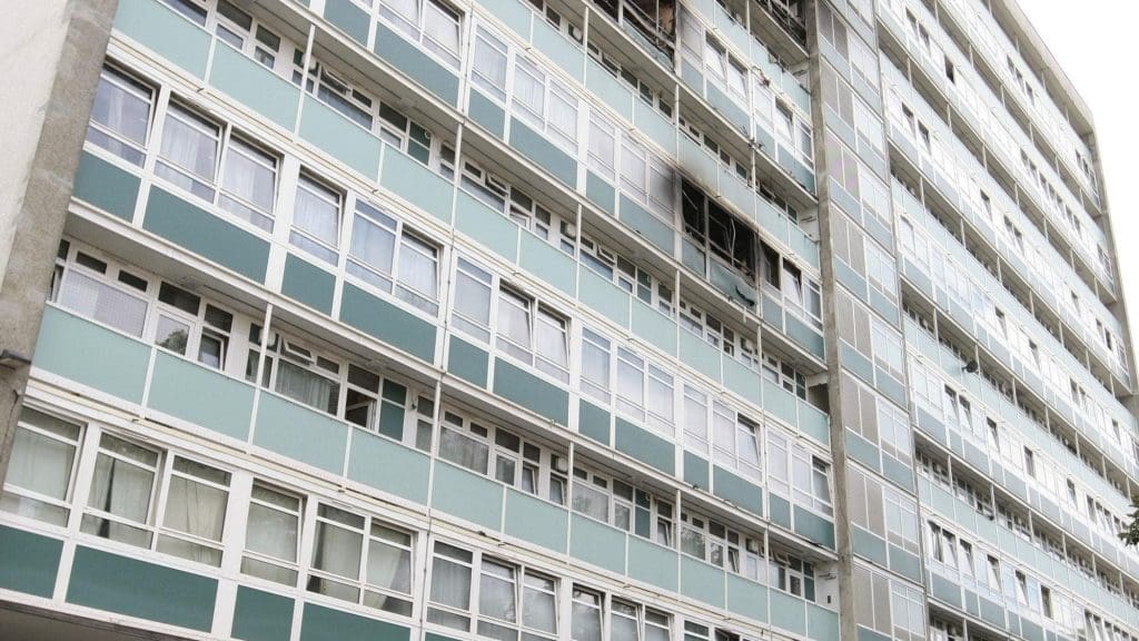 The bottom of Grenfell Tower with two police officers standing beside it