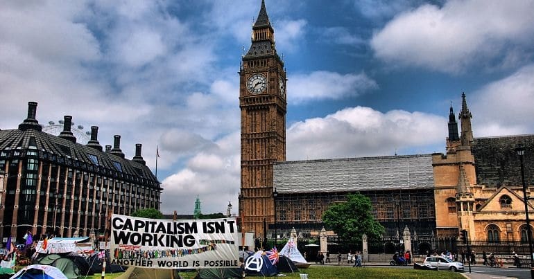 A sign reading 'Capitalism isn't working' outside the Houses of Parliament