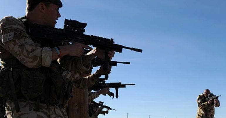 Soldiers in a line aiming their rifles