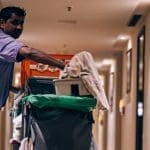 A cleaner in a hotel hallway with his equipment TUC Covid Inquiry