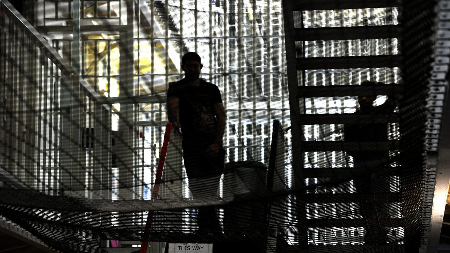 A prisoner standing in the shadows in a cell block