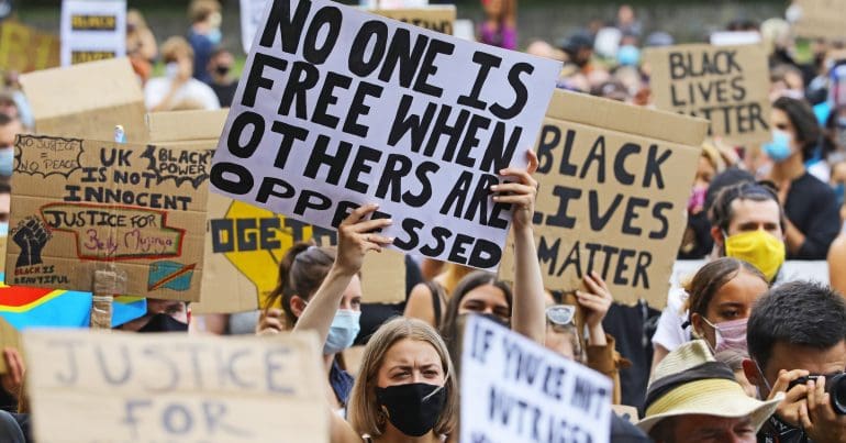 Anti-racism protestors holding up placards