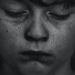 Black and white photo of a boy crying