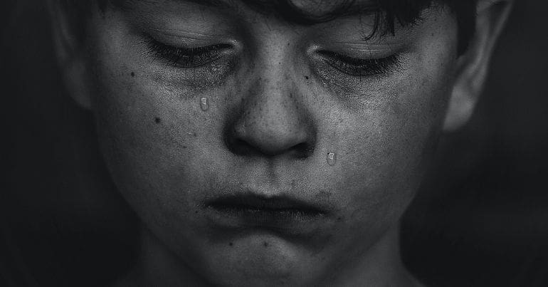 Black and white photo of a boy crying