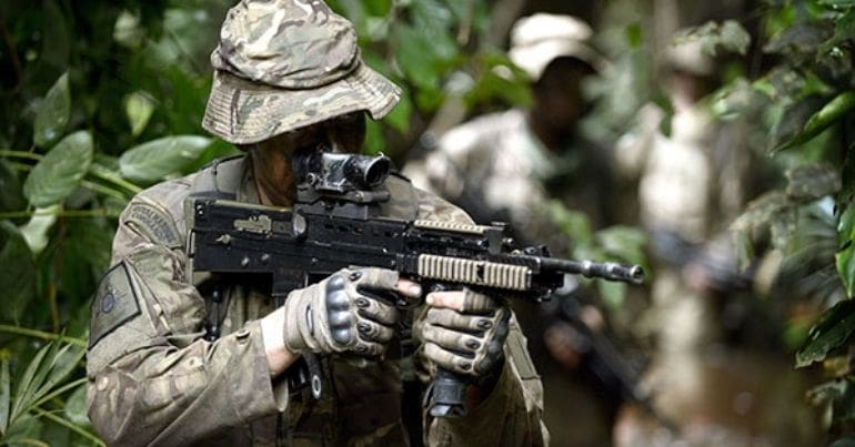 A soldier in camouflage holding a rifle