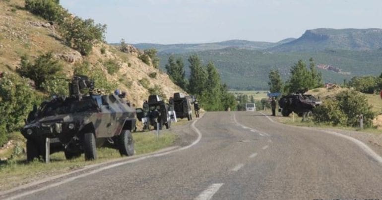 Military vehicles by the side of a road