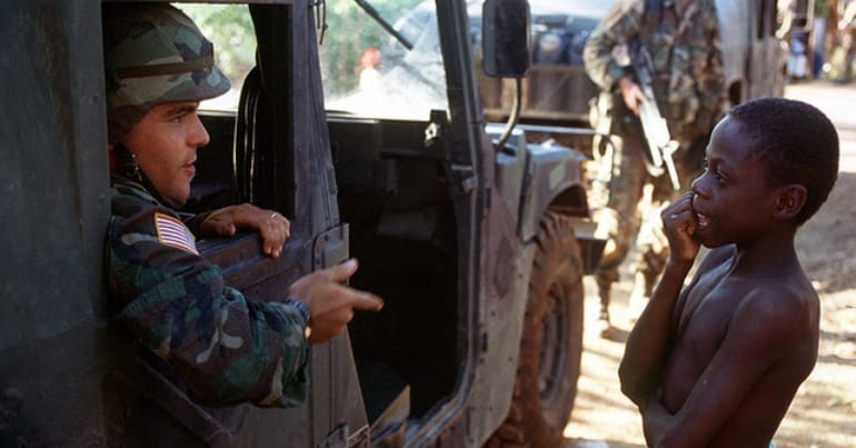 A US soldier talking to a Haitian boy