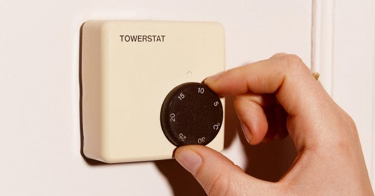 Someone adjusting a thermostat