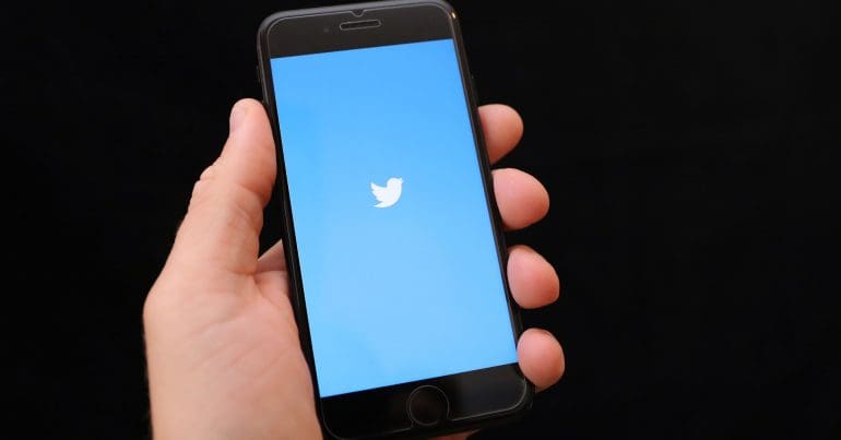 A mobile phone displaying the Twitter logo