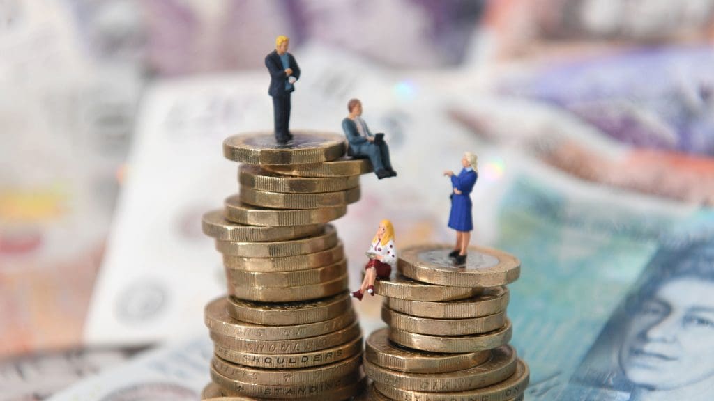 model people on a stack of pound coins