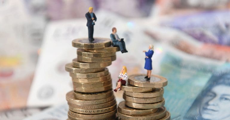 model people on a stack of pound coins