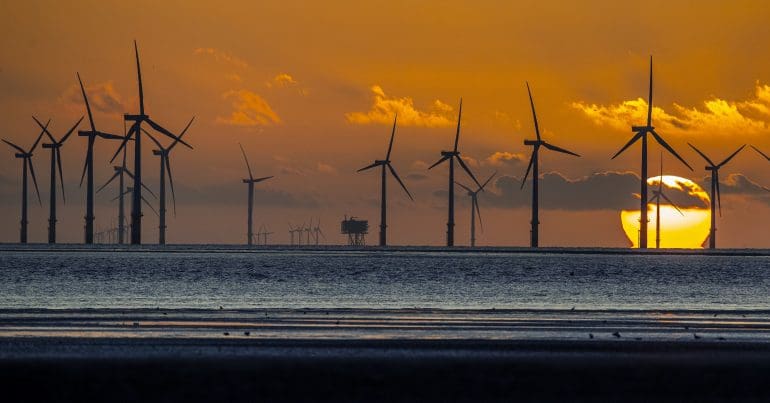 The sun setting behind offshore windfarms