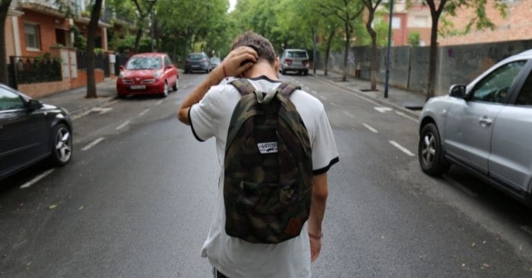 Young person walking down an empty street