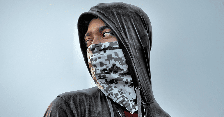 A young black man wearing a hoodie and face covering