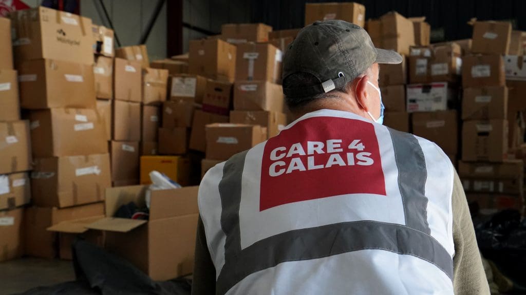 Care 4 Calais workers in a warehouse filled with boxes