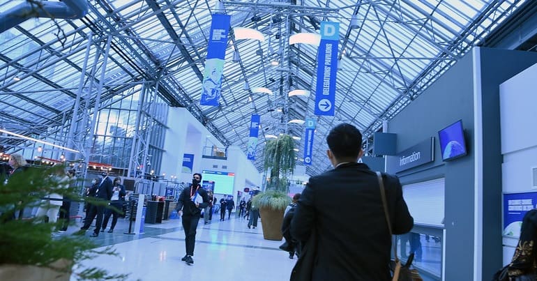 People walk through the concourse at the COP26 centre