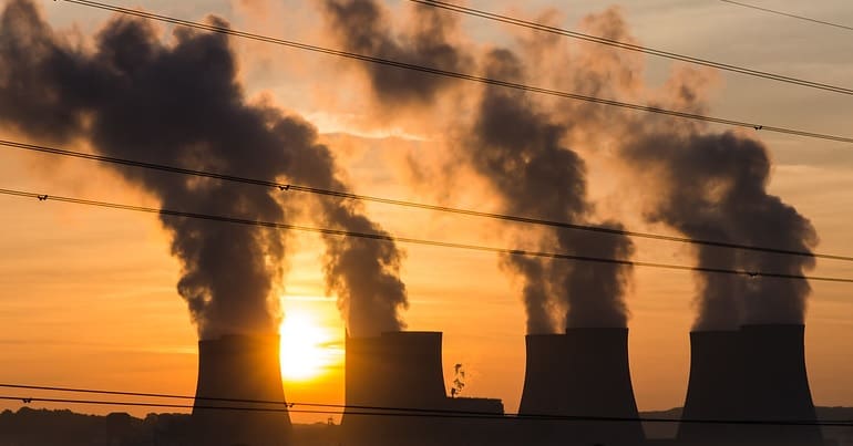 Power station chimneys with the sun in the background