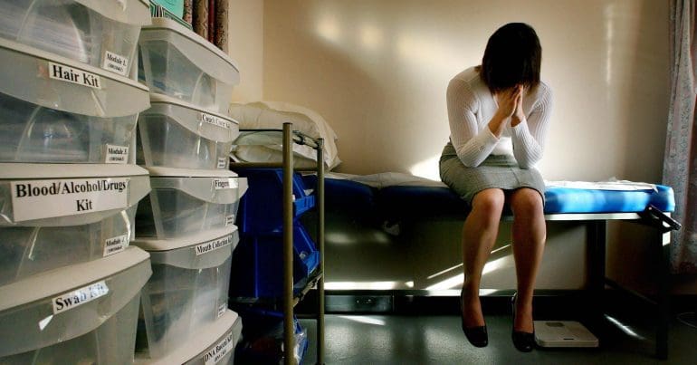 A crying woman sitting in a sterile room