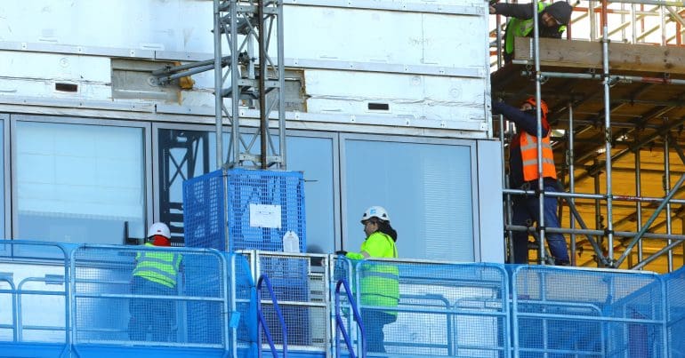 Workers on the side of a building