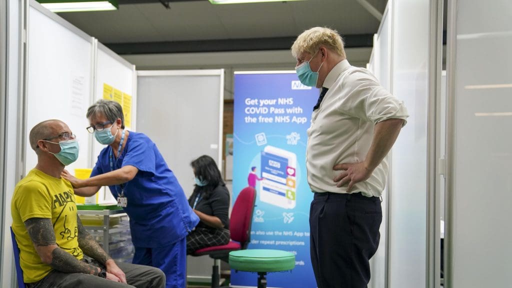 Boris Johnson just staring at a man getting his vaccination from a short distance away