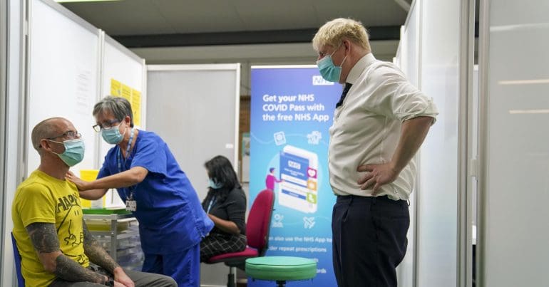 Boris Johnson just staring at a man getting his vaccination from a short distance away