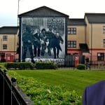 A picture of the Bloody Sunday mural in Derry with Keir Starmer looking at it