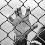 man holding chain-link fence