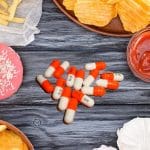 A plate of junk food with eating disorder treatment vyvanse tablets