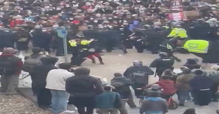 Mariella being kicked to the ground by riot police