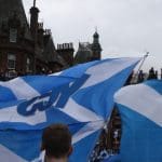A Scottish independence march displaying several saltires, one defaced with the YES campaign logo