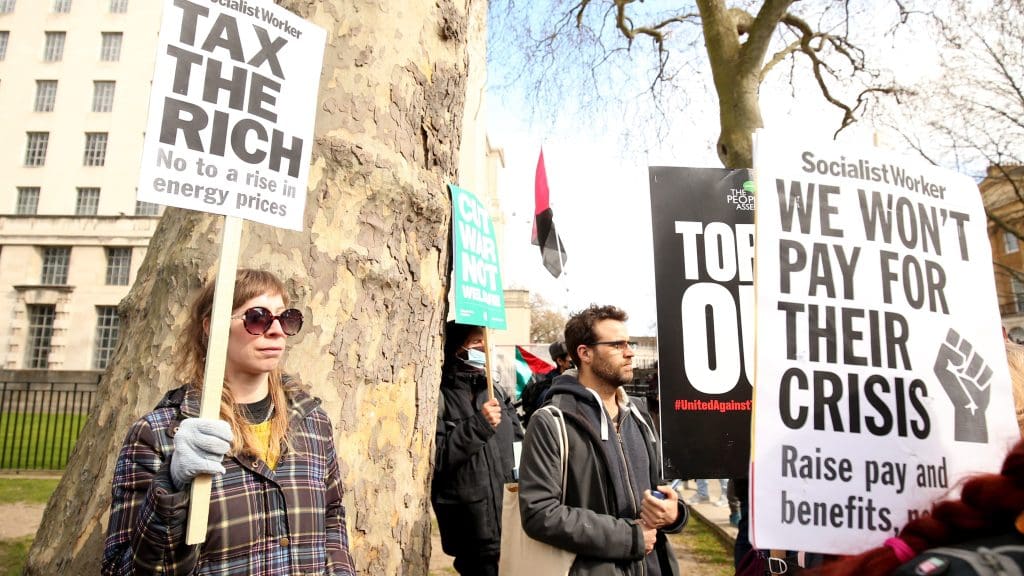 Protesters holding signs which read 'tax the rich'