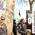 Protesters holding signs which read 'tax the rich'