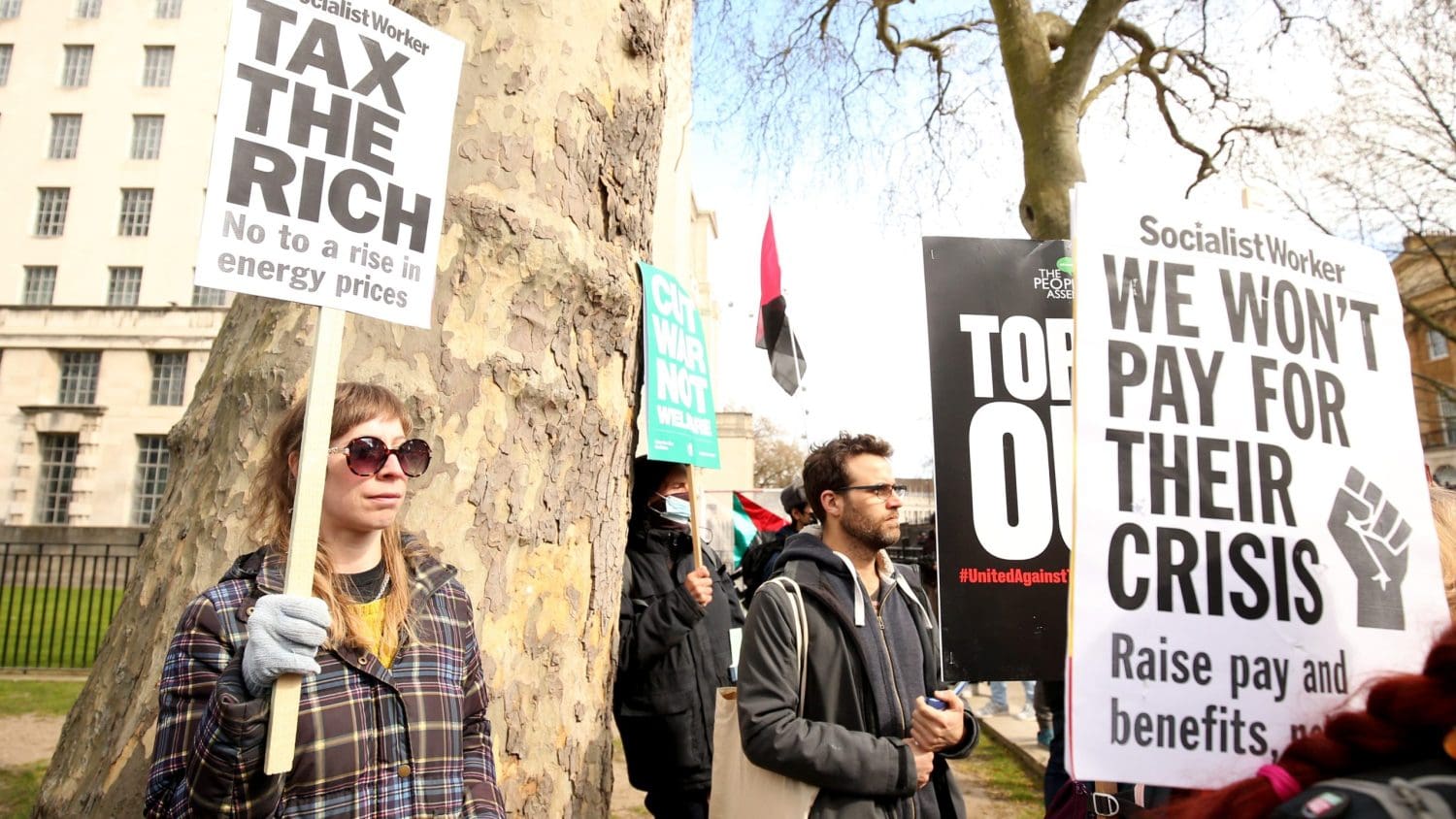 Protesters holding signs which read 'tax the rich'