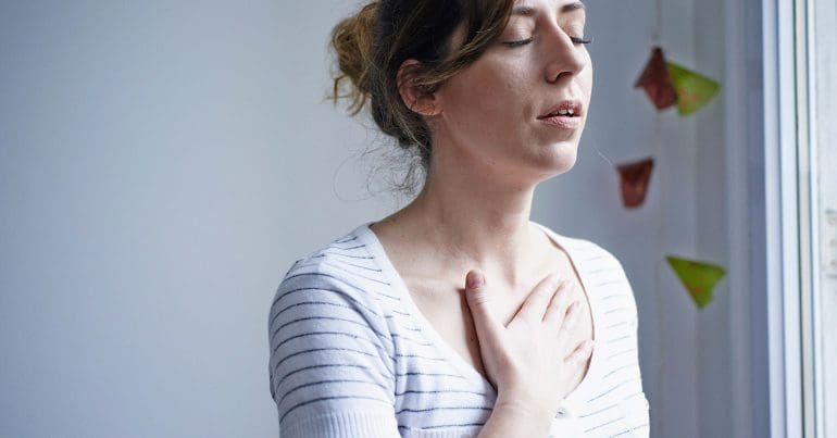 A woman holding her hand to her chest