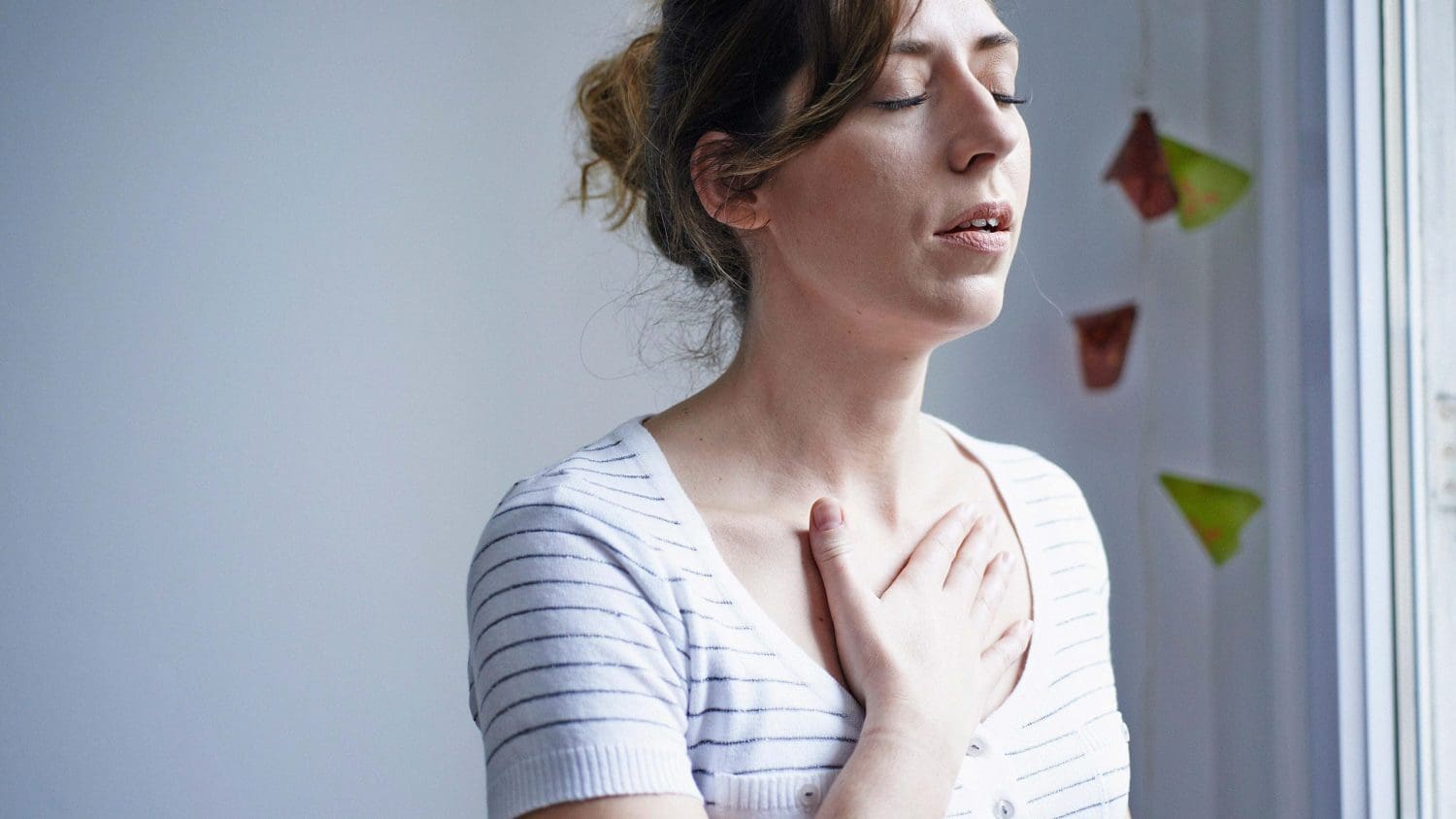 A woman holding her hand to her chest