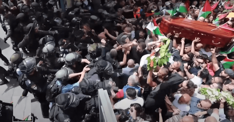 Crown of mourners carrying Shireen Abu Akleh's casket at her funeral