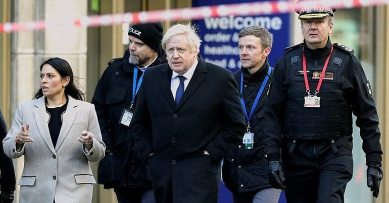 Johnson and Patel walking with police officers