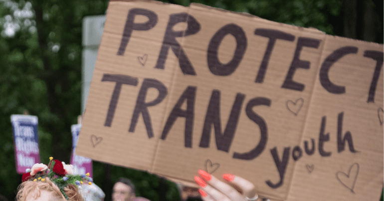 a sign saying "protect trans youth"