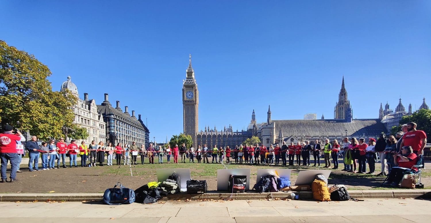 People at a Millions Missing demo linking together with a red ribbon