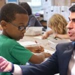 A child in education and Rishi Sunak pointing at him