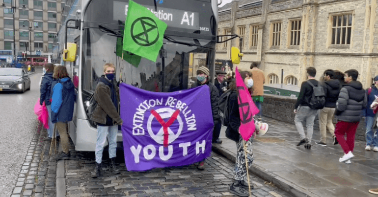 Extinction Rebellion protesters in Bristol holding up a bus