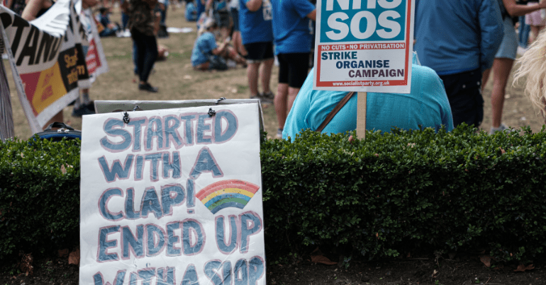protest sign reads "started with a clap, ended with a slap" representing the RCN and nurses NHS strike