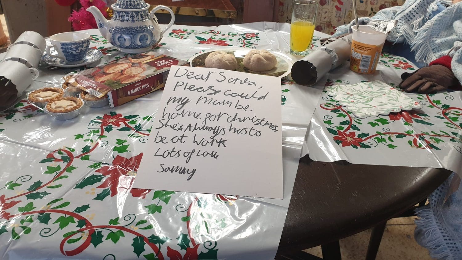 A note which reads "Dear santa, can my mum please be at home for Christmas, she always has to work"