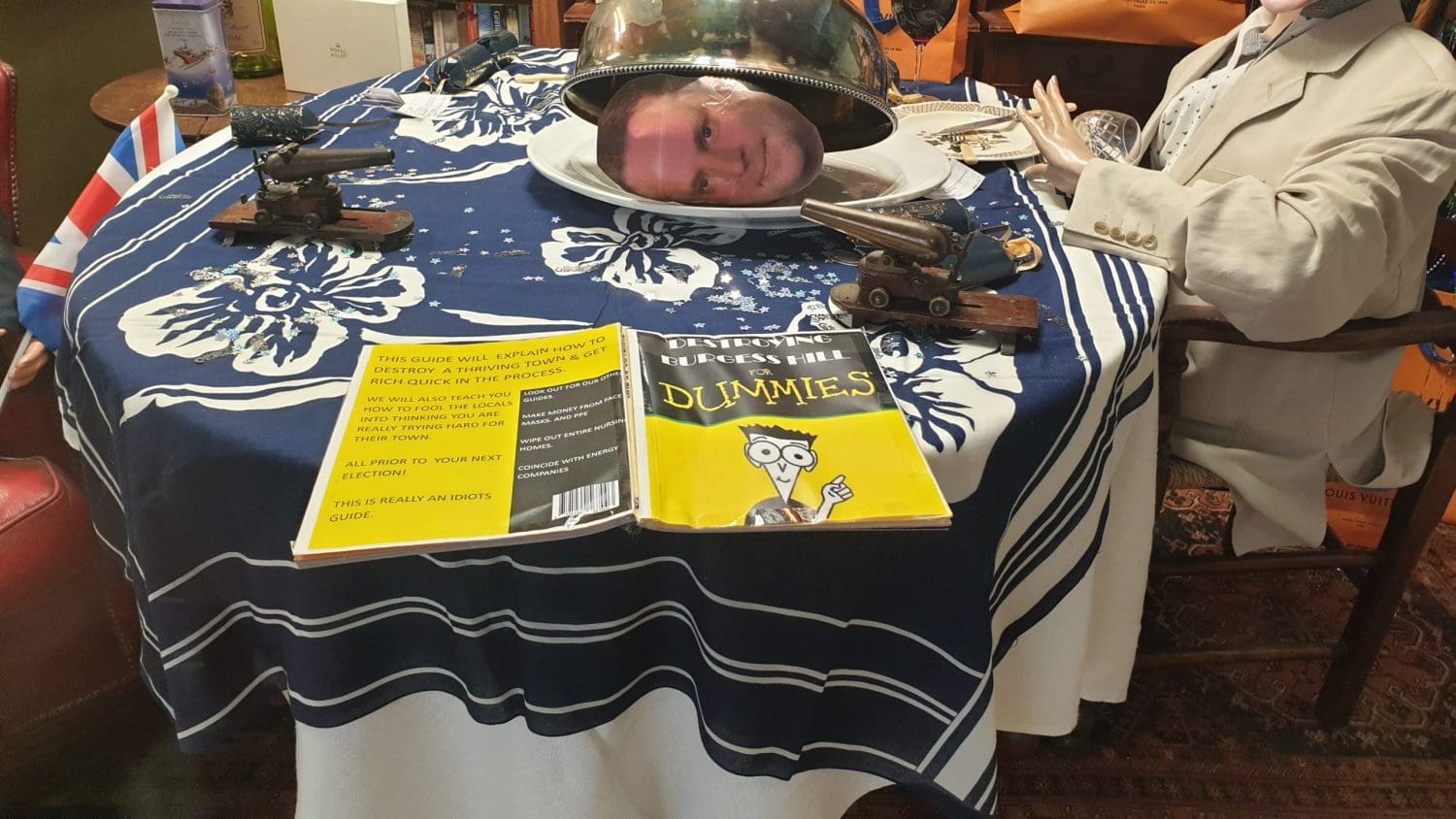 The Tories dining table with a book called "Destroying Burgess Hill for Dummies", aimed at the local Tory MP