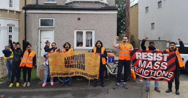 London Renters Union protest with a sign that reads standing up to landlords