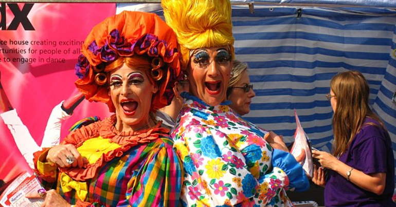two panto dames stand back-to-back